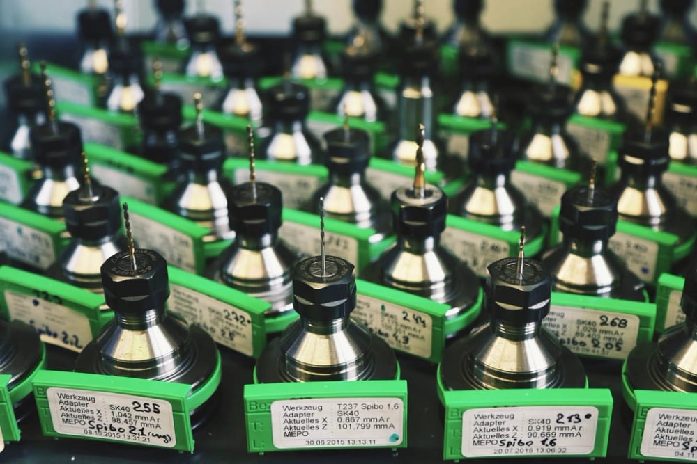 Rows of CNC tool holders with drill and mill bits seated in them.